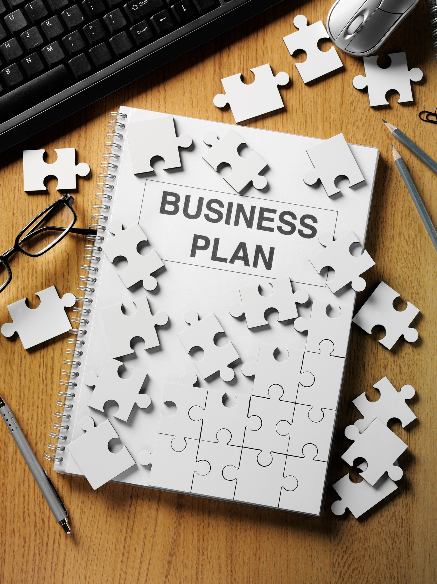 Business Plan and a Jigsaw on the Office Desk